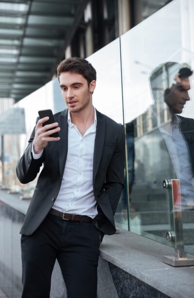 Man bekijkt mobiele telefoon met melding over zijn reservering of afspraak